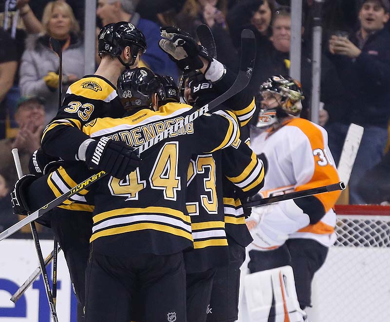 Chris Kelly, 23, celebrates his goal with teammates Zdeno Chara, 33, and Dennis Seidenberg as Flyers goalie Ilya Bryzgalov stands in the goal in the first period Saturday in Boston. The Bruins won 3-0.