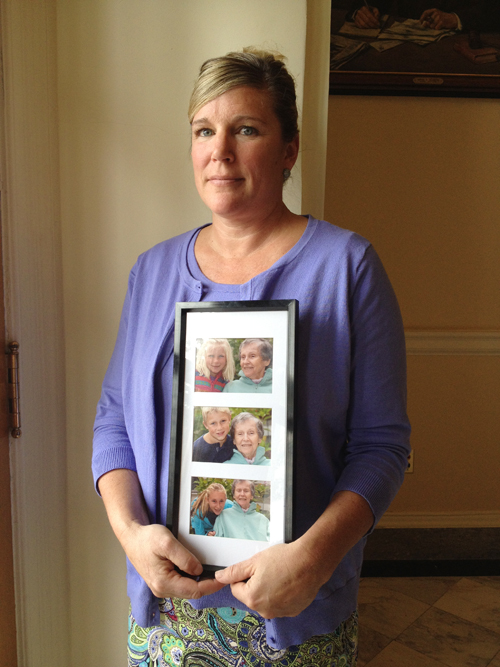 Sally Tartre of Kennebunk, whose late mother, Connie Roux, had Alzheimer's disease, spoke Thursday at a State House news conference presenting Maine's first strategic plan to address dementia-related issues. She holds a frame of photos of her three children taken with their grandmother six weeks before she died in December 2011.