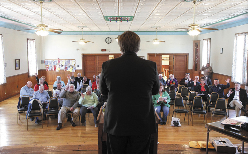 Residents vote on an article as moderator David Benier presides over the annual Benton Town Meeting, inside the Benton Grange Hall, on Saturday.