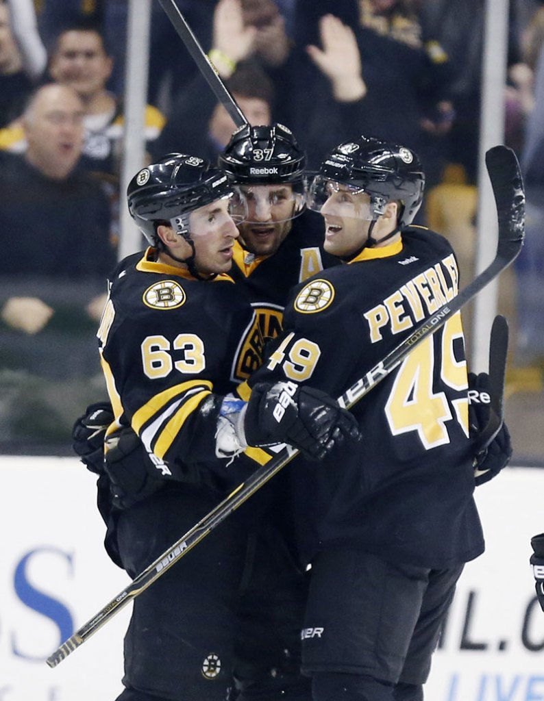 Boston Bruins' Brad Marchand (63) celebrates his go-ahead goal with teammates Patrice Bergeron (37) and Rich Peverley (49) during the third period of an NHL hockey game against the Tampa Bay Lightning in Boston, Saturday, March, 2, 2013. The Bruins won 3-2. (AP Photo/Michael Dwyer)