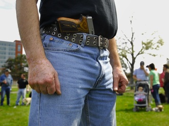 In this April 2010 file photo, a pro-gun demonstrator who did not want to be identified stands in a park at Back Cove in Portland during a gathering to publicize the right to carry unconcealed weapons. The concealed-weapons permit data bill that sparked the year's most visceral public policy debate is up for its public hearing Tuesday, and a big crowd is expected.