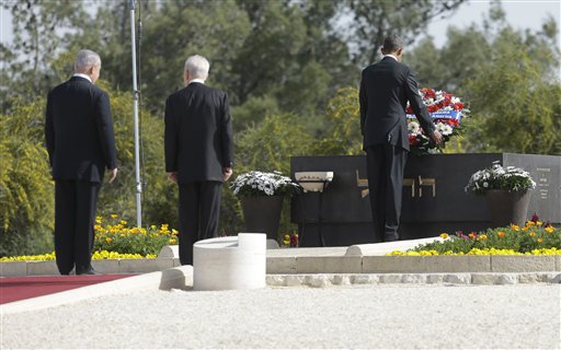 U.S. President Barack Obama, right, with Israeli President Shimon Perez, center, and Israeli Prime Minister Benjamin Netanyahu stand behind, lays a wreath at the grave of Theodor Herzl during his visit to Mt. Herzl in Jerusalem, Israel, Friday, March 22, 2013. (AP Photo/Pablo Martinez Monsivais)