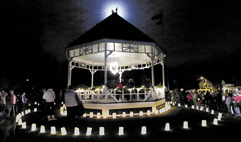 This 2006 file photo shows the moon rising behind people standing around the gazebo on Gardiner Common at the conclusion of the hospice luminaria lighting event on the Common in Gardiner. The structure, torn down in 2012, will be replaced, but when and what it will look like are open questions.