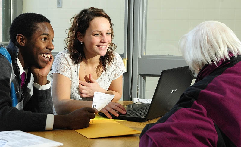 Capital Area Technical Center students Dayshawn Roberts, left, and Emma Madison chat with tax preparation client Eula Roberts, of Augusta, as they do her taxes on Thursday at their school in Augusta.
