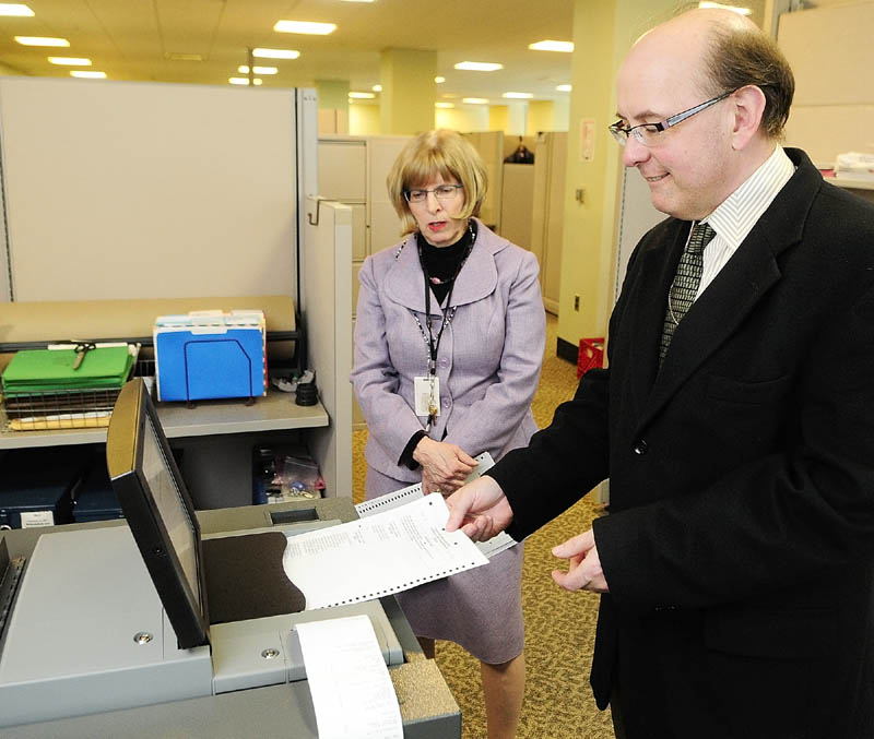 Deputy Secretary of State Julie Flynn, left, and Secretary of State Matt Dunlap give a demonstration of one of the the new, state-leased DS 200 tabulators on Thursday in the Cross Building in Augusta. Litchfield recently rejected a second offer by the state for a machine to tabulate state and federal election ballots, in favor of continuing hand-counting.