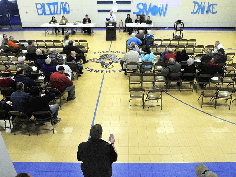 Ryan Harmon, standing lower center, speaks during a debate on road paving during the annual town meeting on Saturday at the Palermo Consolidated School.