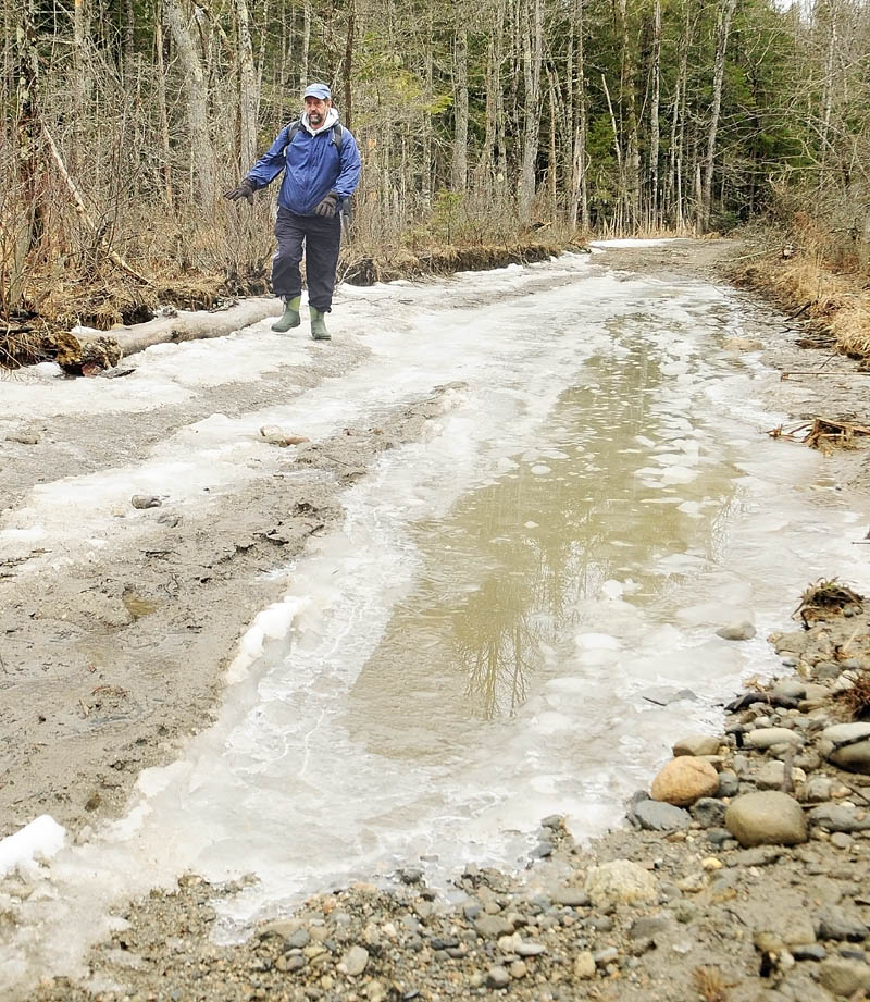 Bill Seekins walks along a flooded section of access road on Thursday during a tour of Thurston Park in China. Seekins said he applied to have the Maine National Guard engineering battalion work on the road as part of their training over this summer.