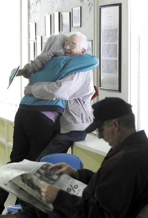 Rome resident Richard H. LaBelle smiles while getting a hug from friend Alice VanDerwerken, before the start of the annual Rome town meeting on Saturday. VanDerwerken said she and LaBelle have known each other for more than 20 years.