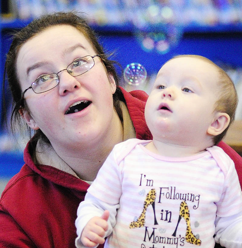 Crystal Callahan, left, and her daughter, Olivia Callahan, 9 months, watch bubbles during the Incredible Infants event on Friday in the Titcomb Children's Room at the Lithgow Library in Augusta. Every Friday from 10 to 10:30 a.m. library aide Jeanne Frost leads a program of songs and games for infants and their caregivers.