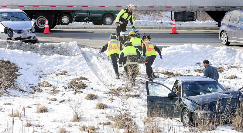 Augusta firefighters carry a person on backboard away from a car that slid off the road around toward a waiting stretcher around 5 p.m. on Friday, after a three-vehicle collision near Riverside Drive and Route 3 in Augusta. The accident took place in the northbound lane of Riverside Drive, just before the traffic light at Route 3. Additional details were unavailable early Friday evening.