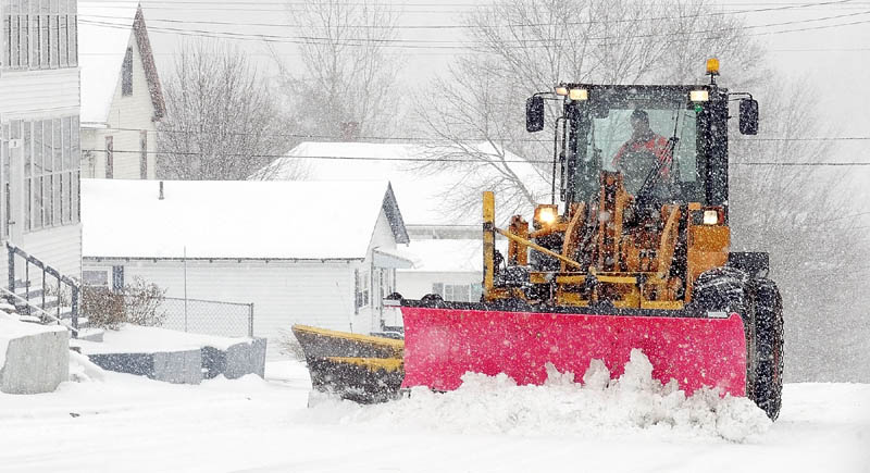 A city front-end loader pushes snow from Monroe Street as more falls during a late winter storm on Tuesday in Augusta's Sand Hill neighborhood.