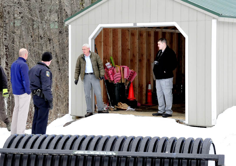 Waterville Police Detective Alan Perkins, center, speaks with Waterville Parks and Recreation Director Matt Skehan, at left, near a shed from which two snowmobiles were stolen, at the Quarry Road Recreation Area, on Monday.