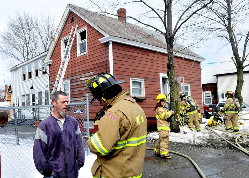 Homeowner Barry Dolley speaks with Waterville firefighter Lt. John Gromek as other firefighters extinquish fire in the attic portion of Dolley's home on Sunday. Dolley said he was working in the home earlier and said sparks from a grinder may have ignited cellulose insulation. No injuries were reported and damage was contained to the attic, according to firefighters.
