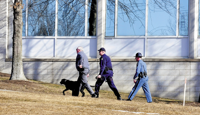 Waterville Police Chief Joe Massey, left, who is also serving as interim chief in Fairfield, leads state troopers and a bomb-sniffing dog into Carter Hall on the Kennebec Valley Community College in Fairfield on Tuesday, after the word "bomb" was discovered in a ladies room earlier. The campus was evacuated as police searched the building.
