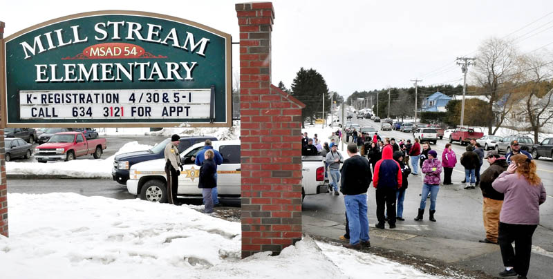 Ruth Perkins speaks with police as parents assemble outside the entrance of the Mill Stream Elementary School in Norridgewock following a report of a man with a rifle nearby on Monday. Police searched the area but did not locate a suspect. Referring to her grandchildren, Perkins said," I just want to get them in my arms."