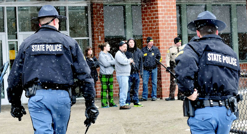 Maine State Police approach parents waiting to enter the Mill Stream Elementary School in Norridgewock following a lockdown on Monday. Police searched the school grounds for a man with a rifle but no suspect was located.