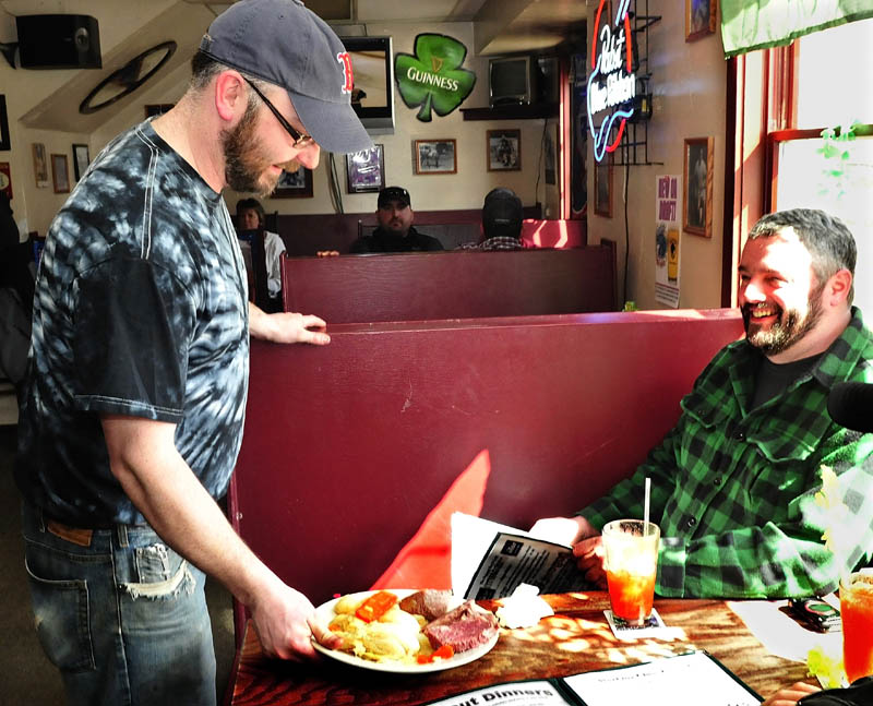 Dugout Bar and Grill owner Shaun Riggs serves an Irish staple of corned beef and cabbage to George Poland at the Farmington eatery on Sunday. Riggs said he does not want to be a bar that sells liquor early in the morning, beginning a 6 a.m., that was allowed due to St. Patrick's day falling on a Sunday. "It's an irresponsible thing," Riggs said.