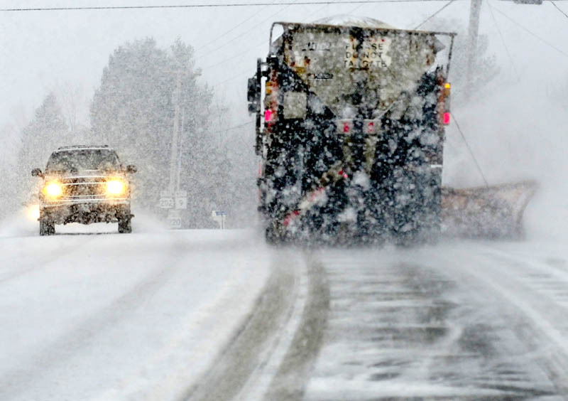 Tuesday's storm created slippery and sometimes whiteout driving conditions as a motorist passes a Maine Department of Transportation plow truck on U.S. Route 202 in Troy.