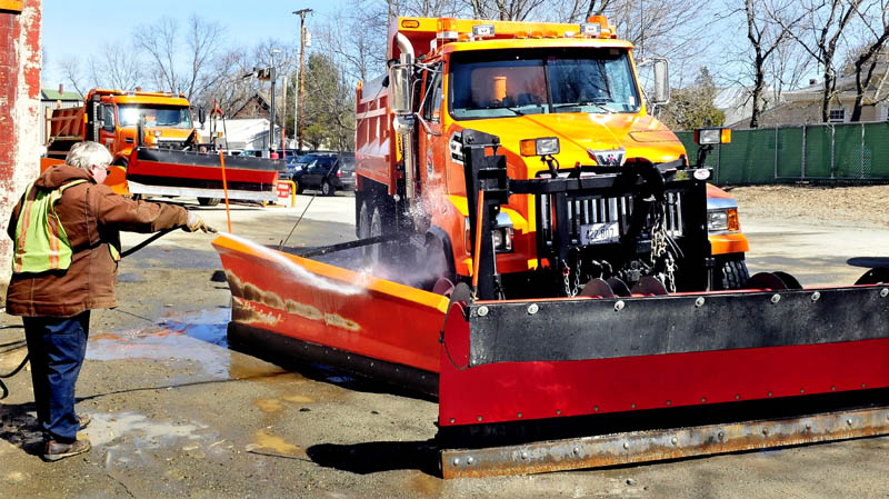 Though it was only a couple days before the official start of spring, Waterville Public Works employee Dan Wilson washes off dirt from one of the city snowplow trucks on Monday. Plows likely will be out in force Tuesday as a significant snowstorm is forecast to dump up to a foot of snow.