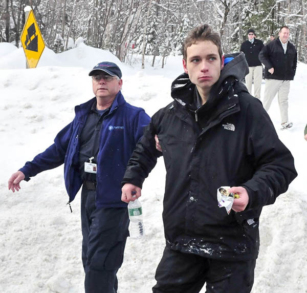 Missing skier Nicholas Joy, 17, of Medford, Mass., is led to an ambulance Tuesday morning after spending two nights lost near Sugaloaf ski area.