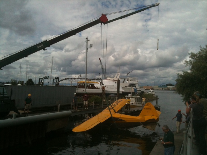 The Stinson plane involved in the fatal crash at Fort Williams Park is lifted onto the dock at South Port Marine in South Portland in this June 26, 2012, photo.