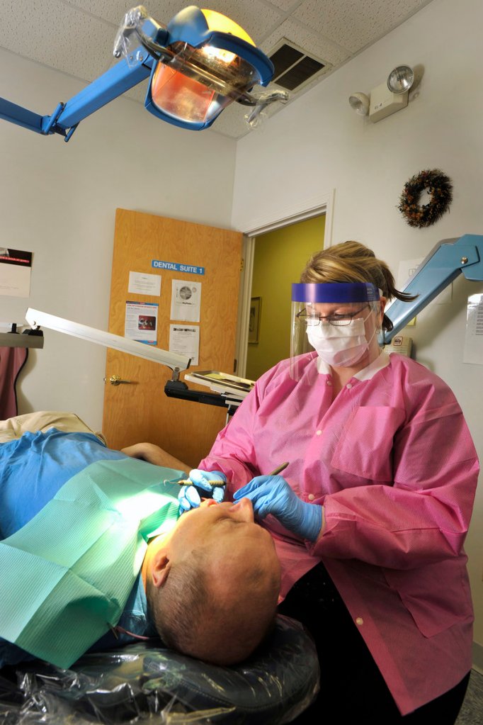 Dental hygienist Torey Richard cleans a patient’s teeth at Clinical Services. Closing the clinic will ultimately prove more costly for the state, said Rep. Denise Harlow.