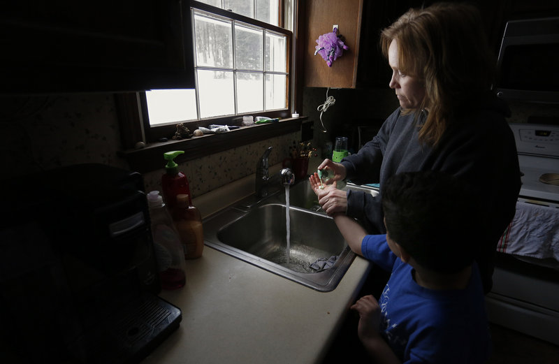 Marie Beaulieu helps Shavar wash his hands. In January, DHHS officials reported a $4.2 million shortfall in the budget for foster care and adoption programs. By June 30, the number of kids in state care is expected to be 35 percent higher than projected.