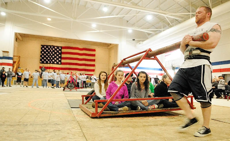 Brian Beaupain, of Waterville, carries several children around in a circle in the Conan's wheel event during the 2013 Central Maine Strongman contest on Saturday at the Augusta armory. Conan's wheel has contestants lifting and carrying a weight around a pivot. The contestant who carries it for the most laps wins.