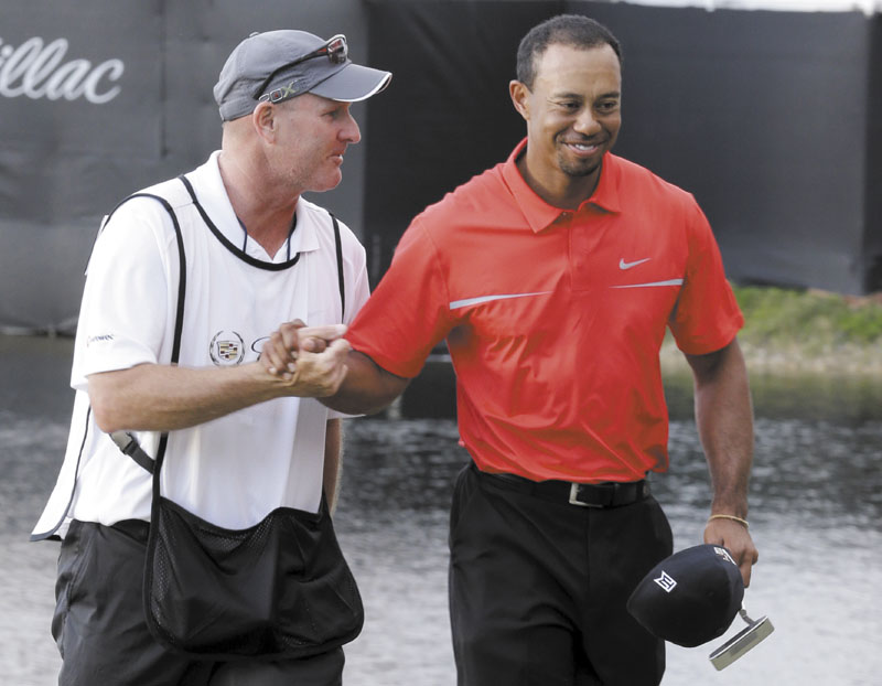 WAY TO GO: Tiger Woods, right, and his caddie Joe Lacava congratulate each other after Woods won the Cadillac Championship on Sunday, in Doral, Fla. WGC-Cadillac World Golf Champio