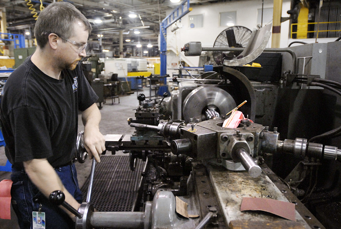 An employee polishes the chamber of a machine gun barrel at the General Dynamics Armament and Technical Products Operation in Saco in this 2007 photo.
