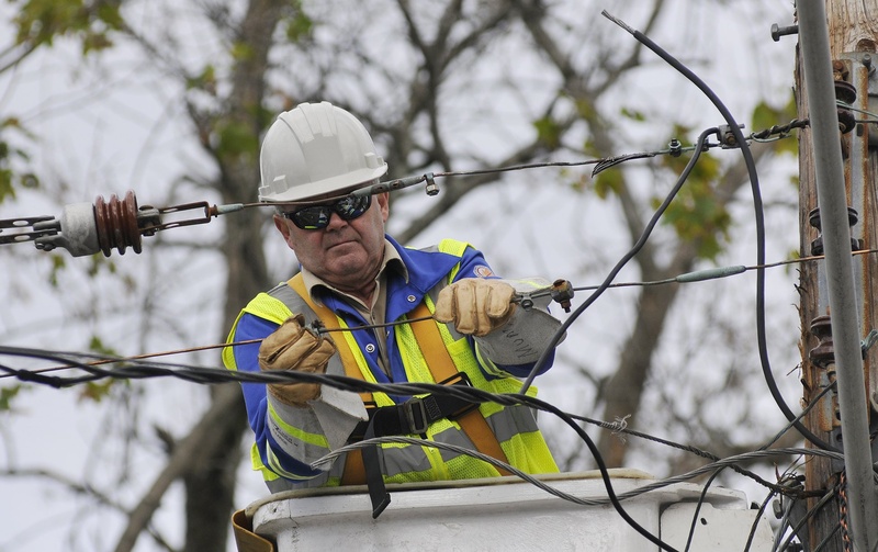 Guy Munn of O'Donnell Line & Electric in Canand works on a power line to restore power on Dyer Street in Saco after a storm.