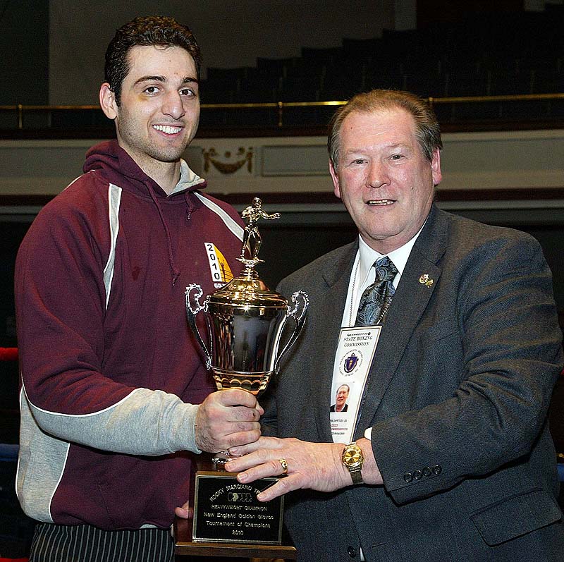 Tamerlan Tsarnaev, left, is shown accepting the trophy for winning the 2010 New England Golden Gloves Championship from Dr. Joseph Downes in Lowell, Mass., on Feb. 17, 2010. Tsarnaev was killed overnight on Friday and the hunt is on for his brother.