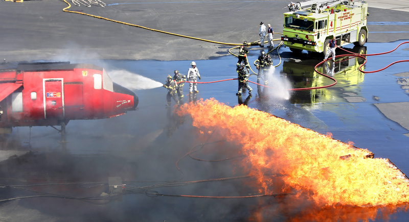 Firefighters conduct an annual FAA training exercise for responding in case of a fire on board a plane at the Portland International Jetport in Portland on Tuesday.