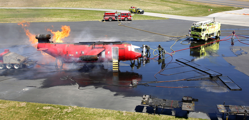 Firefighters practice extinguishing a fire on board a plane as part of an annual FAA training exercise at the Portland International Jetport in Portland on Tuesday.
