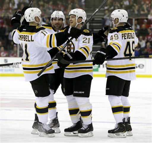 SCORING WAS CHANGED AFTER TRANSMISSION- UPDATES CREDIT OF THE GOAL FROM ANDREW FERENCE TO GREGORY CAMPBELL- Boston Bruins defenseman Andrew Ference (21) celebrates a goal by teammate Gregory Campbell, from left, with teammates Johnny Boychuk, Rich Peverley during the first period of an NHL hockey game against the New Jersey Devils, Wednesday, April 10, 2013, in Newark, N.J. (AP Photo/Julio Cortez)