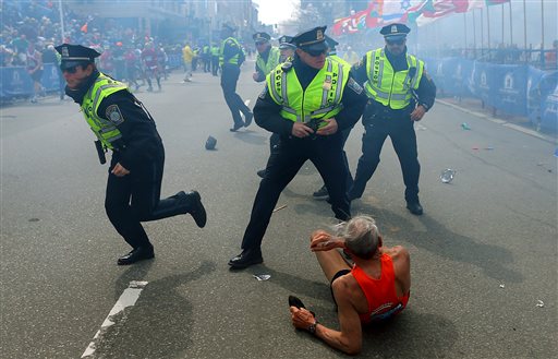 Bill Iffrig, 78, lies on the ground as police officers react to a second explosion at the finish line of the Boston Marathon in Boston on Monday. Iffrig, of Lake Stevens, Wash., was running his third Boston Marathon and near the finish line when he was knocked down by one of two bomb blasts.