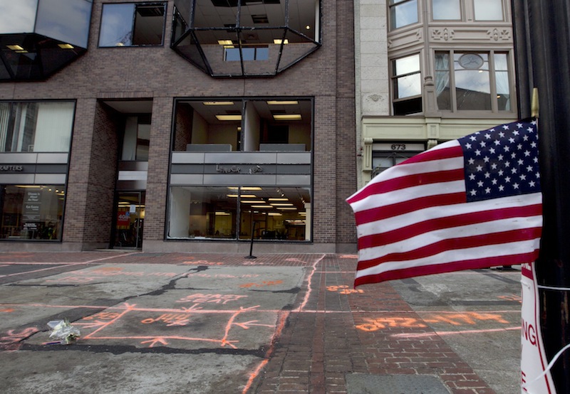 A flag flies at the blast site on Boylston Street between Dartmouth and Exeter Streets near the Boston Marathon finish line Monday, April 22, 2013 in Boston. Federal investigators formally released the finish line bombing crime scene to the city in a brief ceremony at 5 p.m. (AP Photo/Robert F. Bukaty)