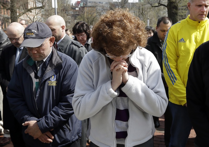 People pause for a moment of silence near the Statehouse in Boston at 2:50pm, Monday, April 22, 2013, exactly one week after the first bomb went off at the finish area of the Boston Marathon. (AP Photo/Elise Amendola)