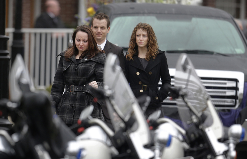 Mourners walk past police motorcycles as they depart St. Patrick's Church in Stoneham, Mass., following a funeral Mass for Massachusetts Institute of Technology police officer Sean Collier, on Tuesday. Collier was fatally shot on the MIT campus on Thursday, allegedly by the Boston Marathon bombing suspects.