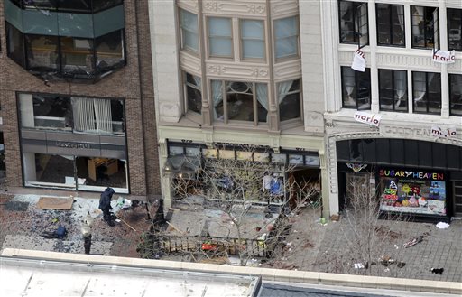 The storefront of Marathon Sports on Boylston Street, near the finish line of the 2013 Boston Marathon, a store owned by former Hall-Dale High School student Colin Peddie, is investigated by a person in a protective suit in the wake of two blasts in Boston on Monday.