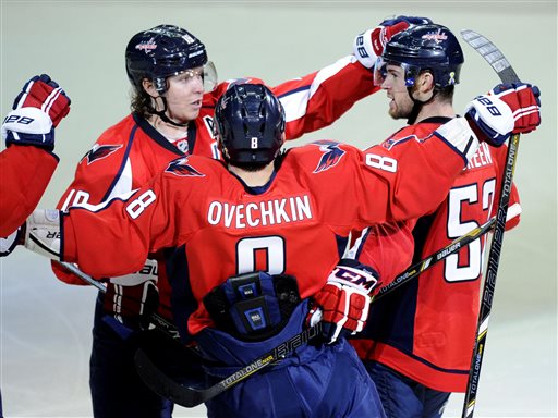 Washington Capitals defenseman Mike Green, right, celebrates his goal with teammates Nicklas Backstrom, left, of Sweden, and Alex Ovechkin (8), of Russia, during the third period of an NHL hockey game against the Boston Bruins, Saturday, April 27, 2013, in Washington. The Capitals won 3-2 in overtime. (AP Photo/Nick Wass)