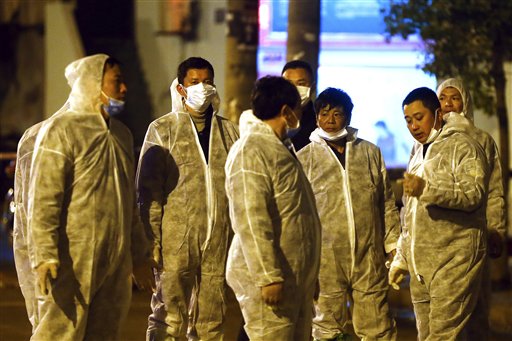 Workers in protective clothing chat during a culling operation as authorities detected the new bird flu strain in pigeons being sold for meat at a wholesale market in Shanghai on Friday.