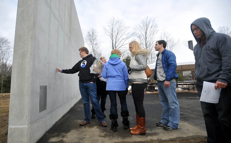 DERRIK'S WALL: Friends and family of Derrik Flahive visit the lacrosse practice wall before the dedication of the Flahive 5 wall at Bill Alfond Field at Colby College on Saturday. The Flahive 5 wall was erected to honor the memory of classmate Derrik Flahive, who drowned while traveling in Chile in 2011.