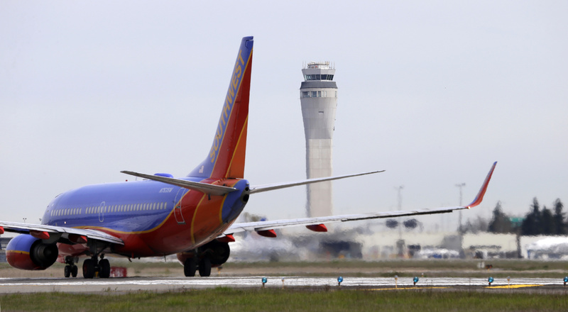 A Southwest airlines jet waits to depart in view of the air traffic control tower at Seattle-Tacoma International Airport in Seattle on Tuesday.