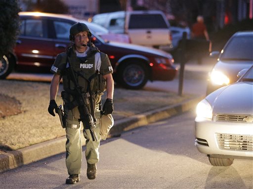 A police officer leaves the scene after an explosion and gunshots were heard where a man was holding four firefighters hostage on Wednesday in Suwanee, Ga.