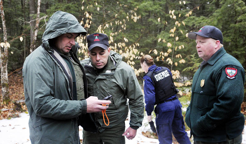 Staff photo by Andy Molloy Game Wardens and State Police get global positioning coordinates before hiking into Christopher Knight's camp in Rome Tuesday April 9, 2013. Police believe Knight, who went into the woods near Belgrade in 1986, was a hermit who committed hundreds of burglaries to sustain himself. His camp is located in a heavily wooded location.