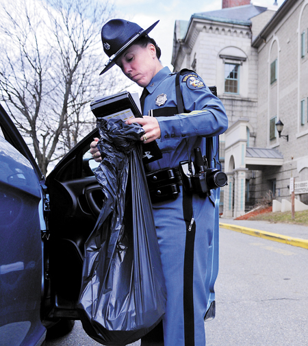 Maine State Police Trooper Diane Perkins-Vance carries a bag of Christopher Knight's clothing she seized from him Sunday, at the Kennebec County jail. Perkins-Vance arrested Knight, alleged to have committed more than 1,000 burglaries while living in the woods for 27 years, on new charges. Knight's bail was increased to $250,000, from $5,000.
