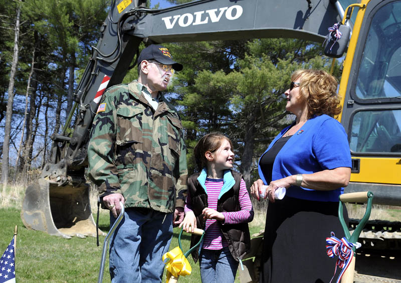 Sophia Jodrey, 8, plays with a shovel while her father, Buddy Jodrey, confers with First Lady Ann LePage during a ground breaking Tuesday for the Veterans Housing Project at Cony Village in Augusta. The elder Jodrey, an Army veteran, is making his first purchase of a home at the development.