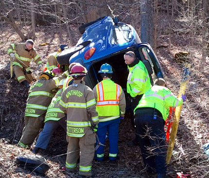 Rescue crews work to get Christina Poulin, 22, of Augusta out of her overturned PT Cruiser Wednesday morning after police said she swerved to avoid a turning car and went over an embankment.