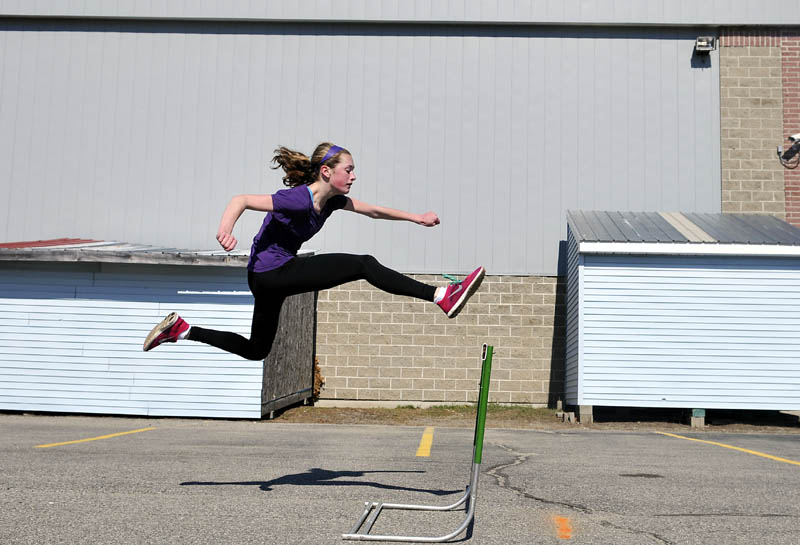 Sammy Grandahl, 15, leaps a hurdle Monday during track practice in the parking lot of Monmouth Academy. The school's athletes have already competed in one meet, coach Norm Thombs said, and are conditioning for several more, even though the school does not have a track to practice upon.